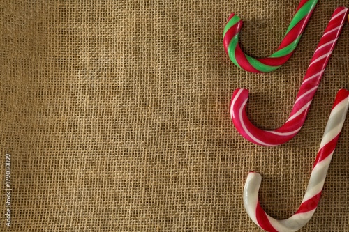 Multicolored candy canes arranged on fabric photo