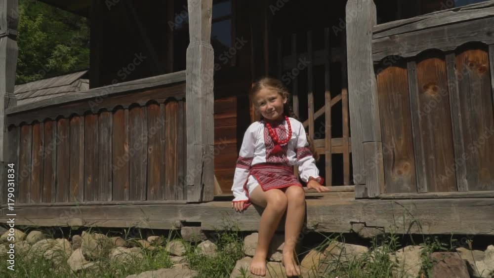 little girl is sitting on the porch of the house Stock ビデオ | Adobe Stock
