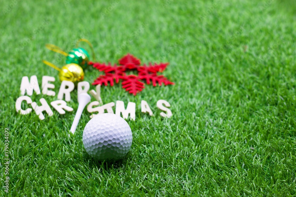 Naklejka premium Merry X'mas to golfer with golf ball and tee on green grass