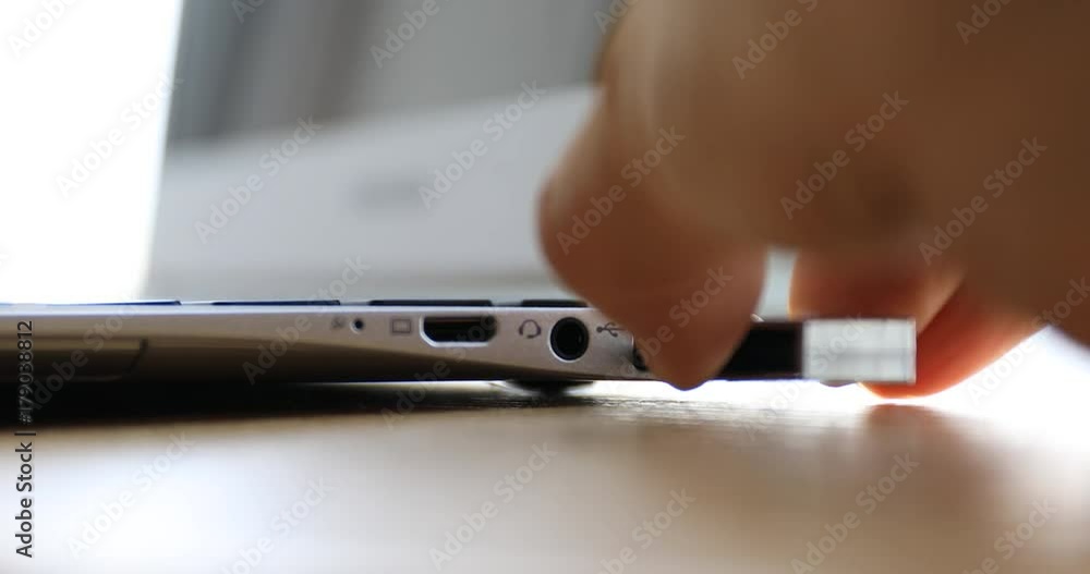 Hand plugging USB flash drive into port of laptop computer Hand plugging USB flash drive into port of laptop computer