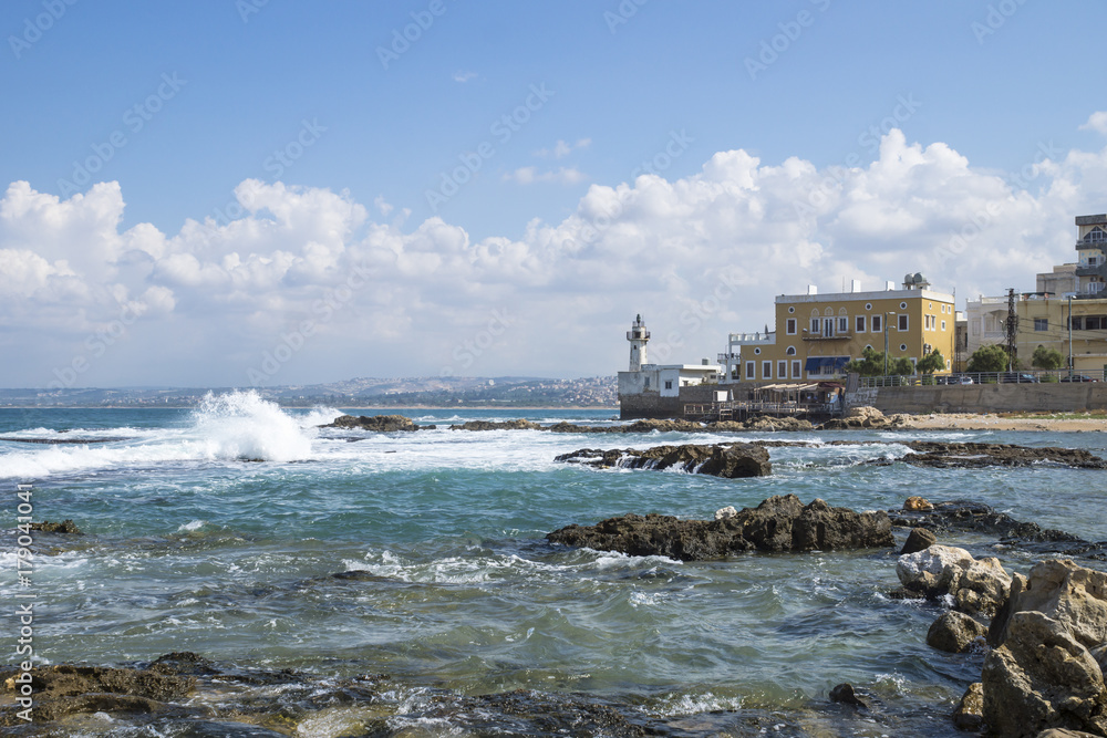 Fototapeta Coastline in Tyre at the ocean with waves and with lighthouse in Tyre, Sour, Lebanon