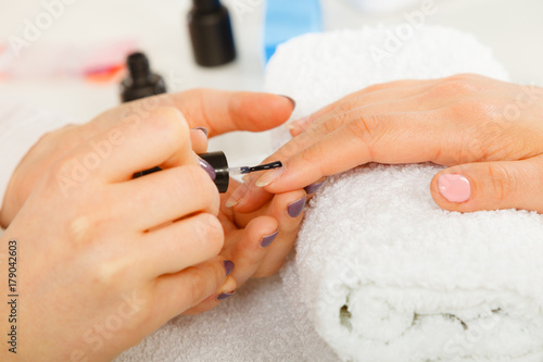 Woman in beauty salon getting manicure done.