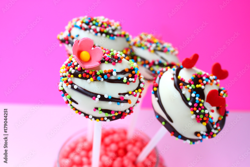 Colorful cake pops on a pink background