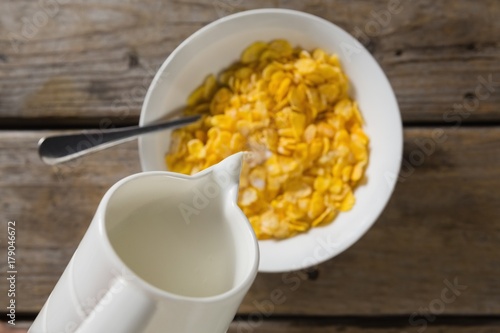 Vászonkép Milk being poured into bowl of wheaties cereal