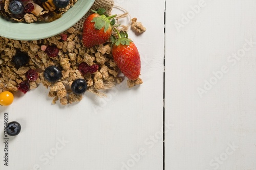 Bowl of breakfast cereals and fruits with spoon photo