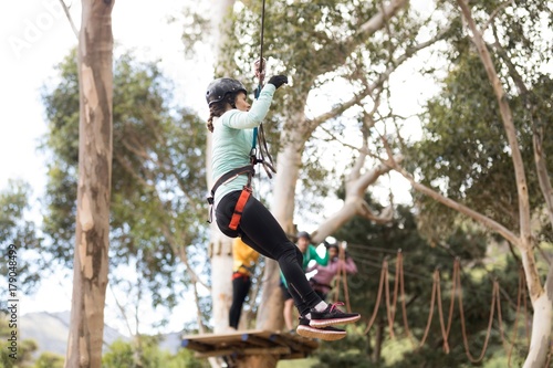 Woman enjoying zip line adventure in park