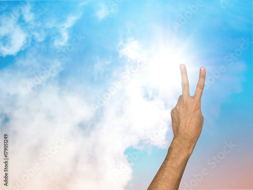 Two fingers and pastel sky background