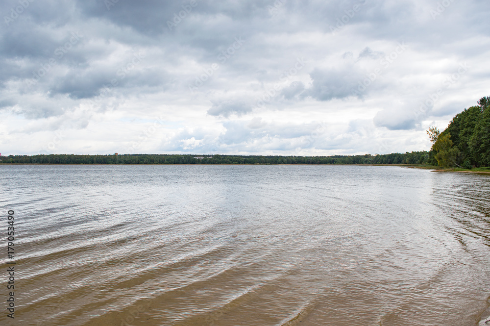 Lake scenery with heavy clouds above the water and forest on the horizon, beautiful nature landscape of lake in Vecstropi, Daugavpils, Latvia