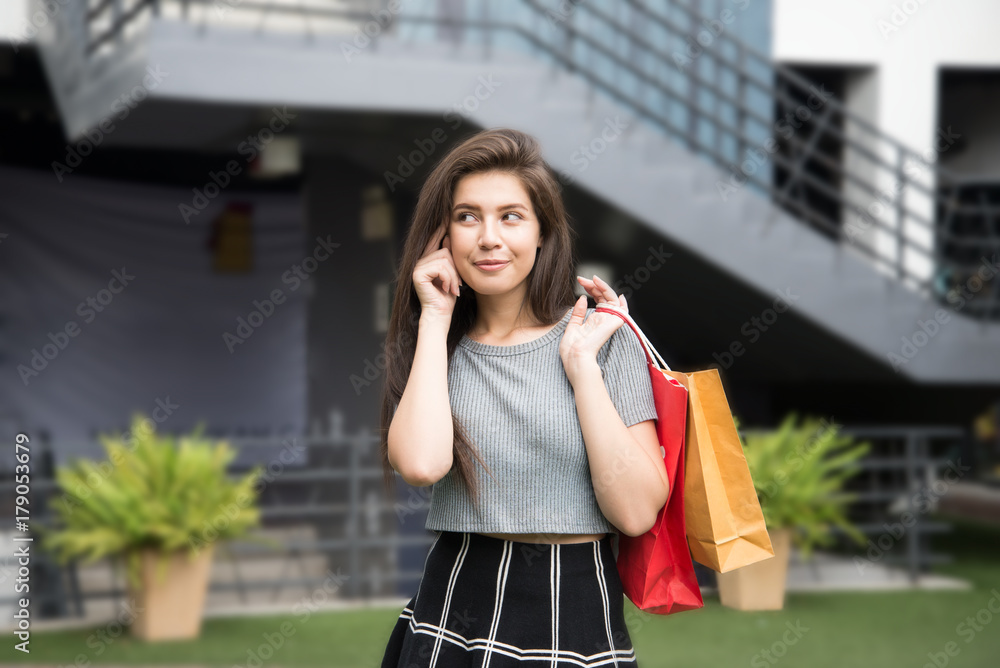 Fototapeta premium Beautiful girl hands hold shopping bag smile and thinking.