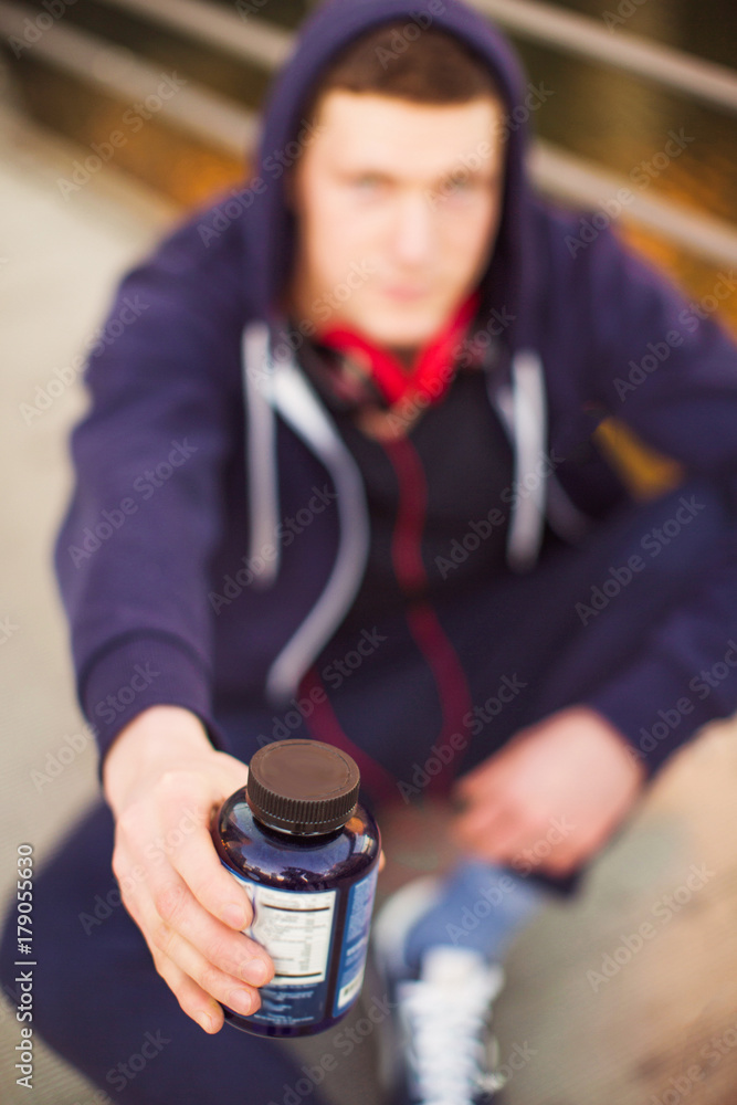 Close-up protein pills in hand of young sporty man outdoors Close-up protein pills in hand of young sporty man outdoors