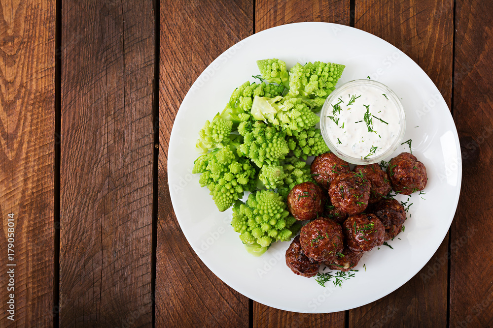 Baked beef meatballs and garnish from boiled cabbage romanesko. Dietary menu. Proper nutrition. Flat lay. Top view Baked beef meatballs and garnish from boiled cabbage romanesko. Dietary menu. Proper nutrition. Flat lay. Top view