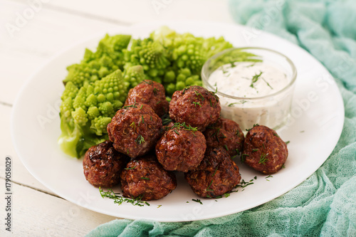 Baked beef meatballs and garnish from boiled cabbage romanesko. Dietary menu. Proper nutrition. photo