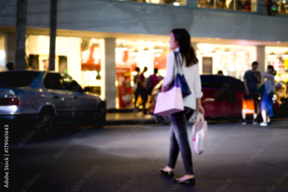 Unidentified woman crossing the road with shopping bag l