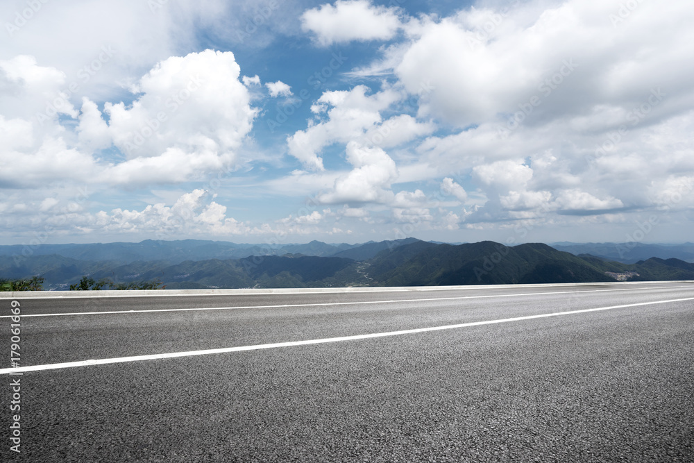 Fototapeta premium empty asphalt road with green hill in cloud sky