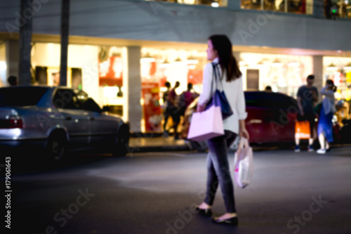 Unidentified woman crossing the road with shopping bag l