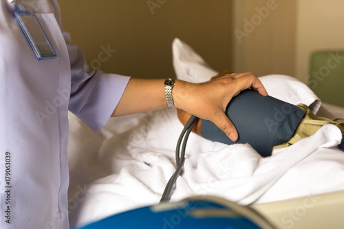 Nurse checking senior man blood pressure