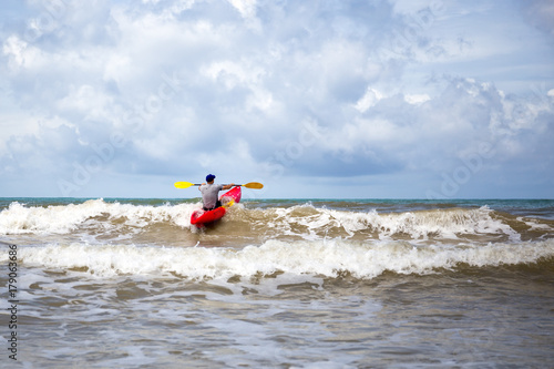 Man with kayak surfing in the sea on summer vacation. Sport concept