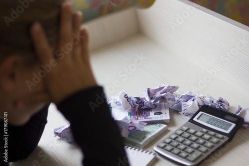 tired business woman sitting at Desk with crumpled banknotes