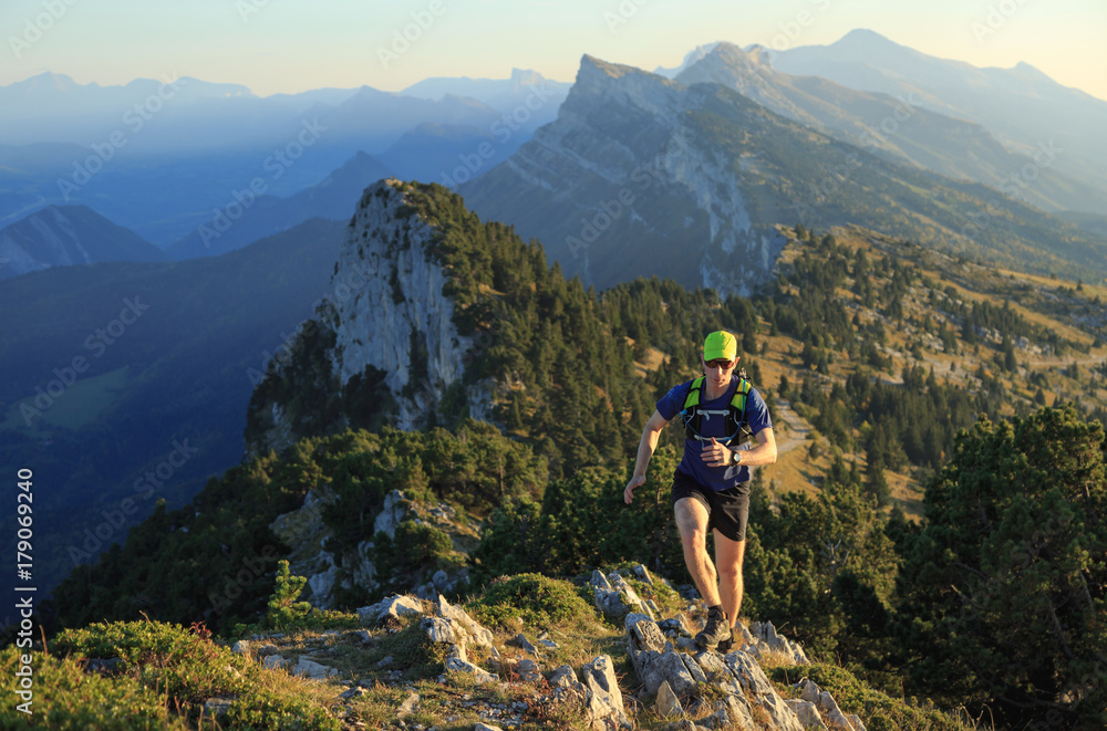 Athlete trailrunning in the mountains on a beautiful afternoon. Vercors, France.