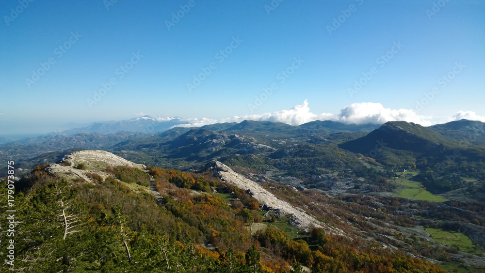 Panoramic view of autumn mountains Lovcen in Montenegro. Views of the peaks of the hills, the colorful trees and stones
