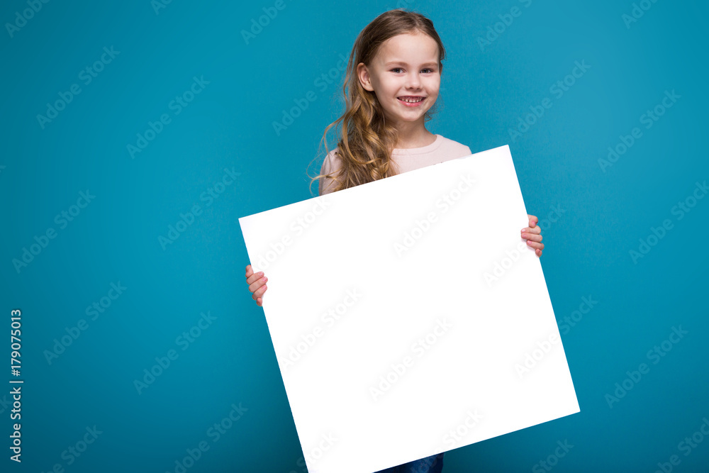 Pretty, little girl in sweater with brunet hair hold clean paper Pretty, little girl in sweater with brunet hair hold clean paper