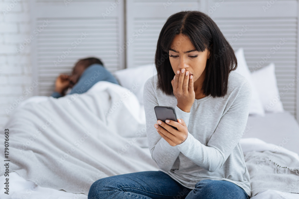 Emotional woman reading an unpleasant message Emotional woman reading an unpleasant message