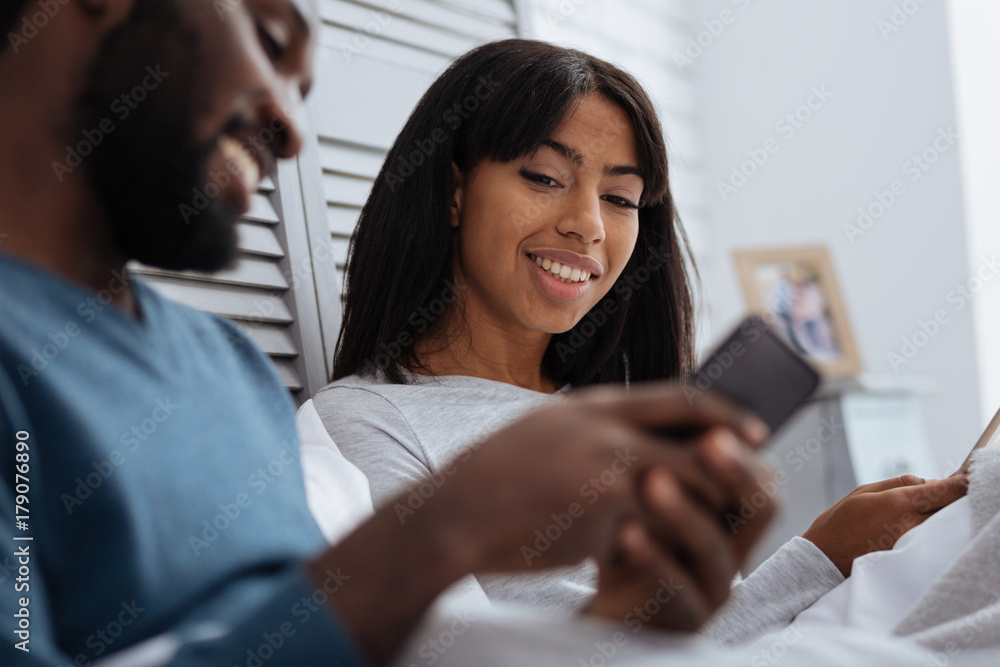 Cheerful happy couple looking at the smart phone Cheerful happy couple looking at the smart phone