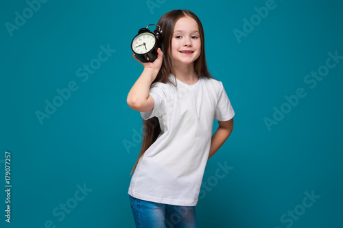 Cute girl in tee shirt with long hair hold the clock