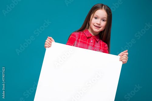Cute little girl in checkered shirt with brunet hair hold clear paper