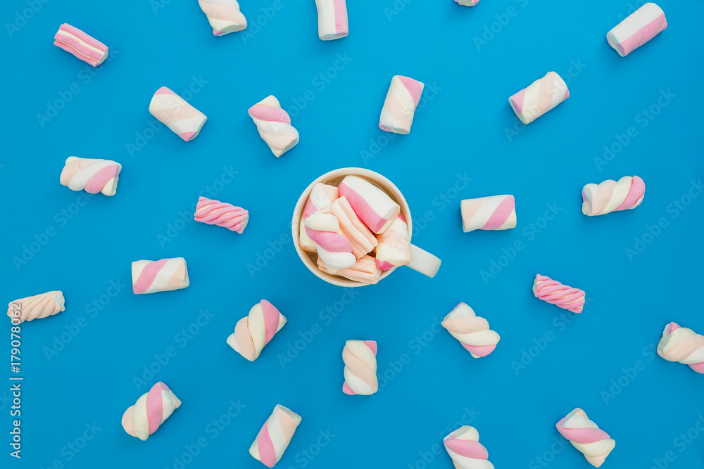 Cappuccino mug with marshmallows on blue background. Flat lay, top view Cappuccino mug with marshmallows on blue background. Flat lay, top view