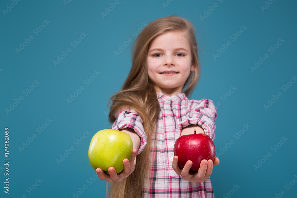 Little beauty girl in shirt with long brown hair with apple in hands Little beauty girl in shirt with long brown hair with apple in hands