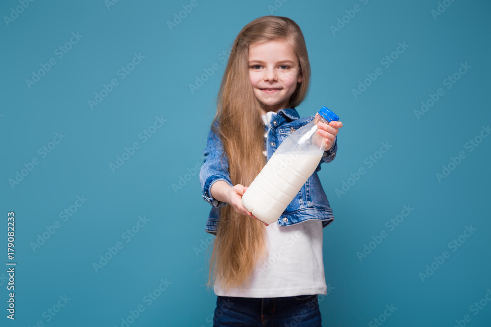 Little pretty girl in jean jacket with long brown hair hold container with milk Little pretty girl in jean jacket with long brown hair hold container with milk