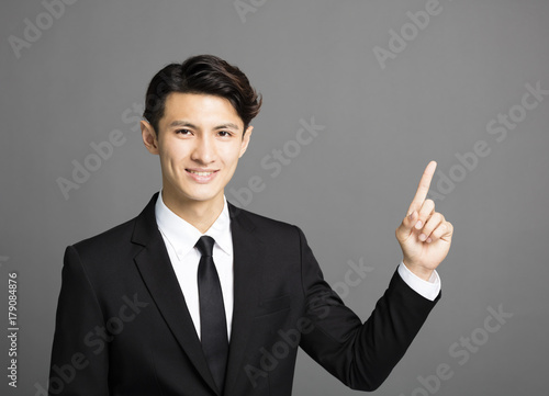 young smiling businessman with gray background