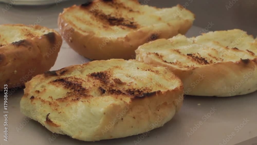 Pan right of toasted buns on the counter. Close up shot. Pan right of toasted buns on the counter. Close up shot.