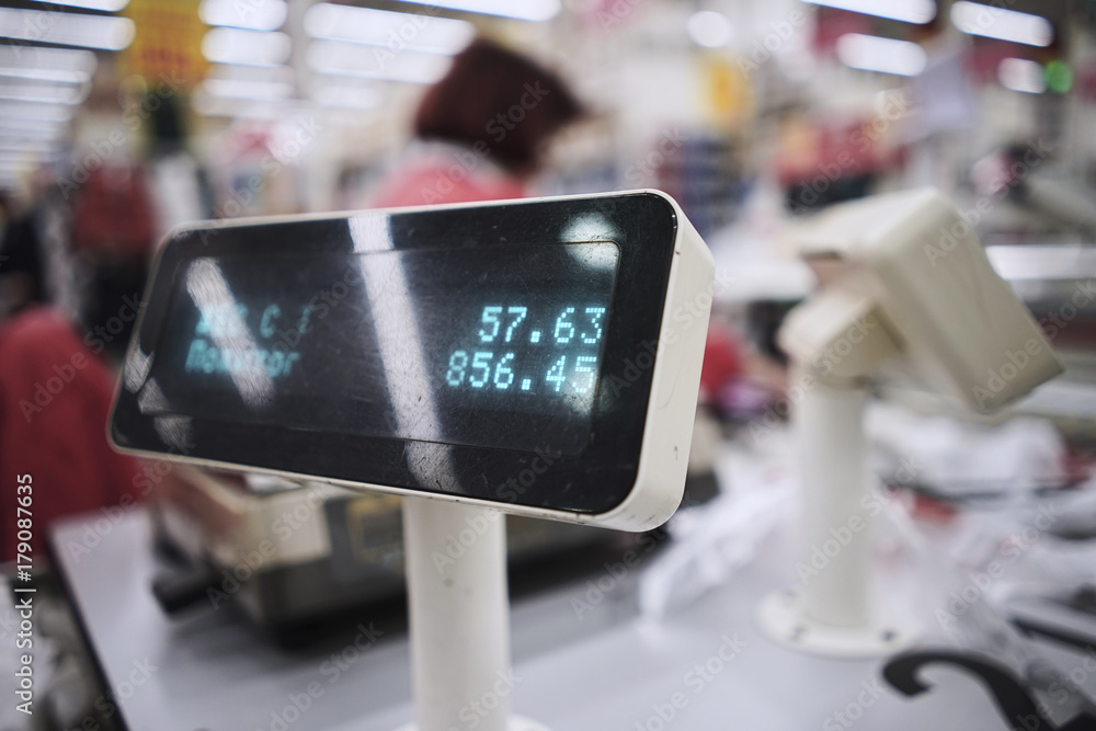 Close-up. The girl pays for purchases at the ticket office. Blurred background of the store Close-up. The girl pays for purchases at the ticket office. Blurred background of the store
