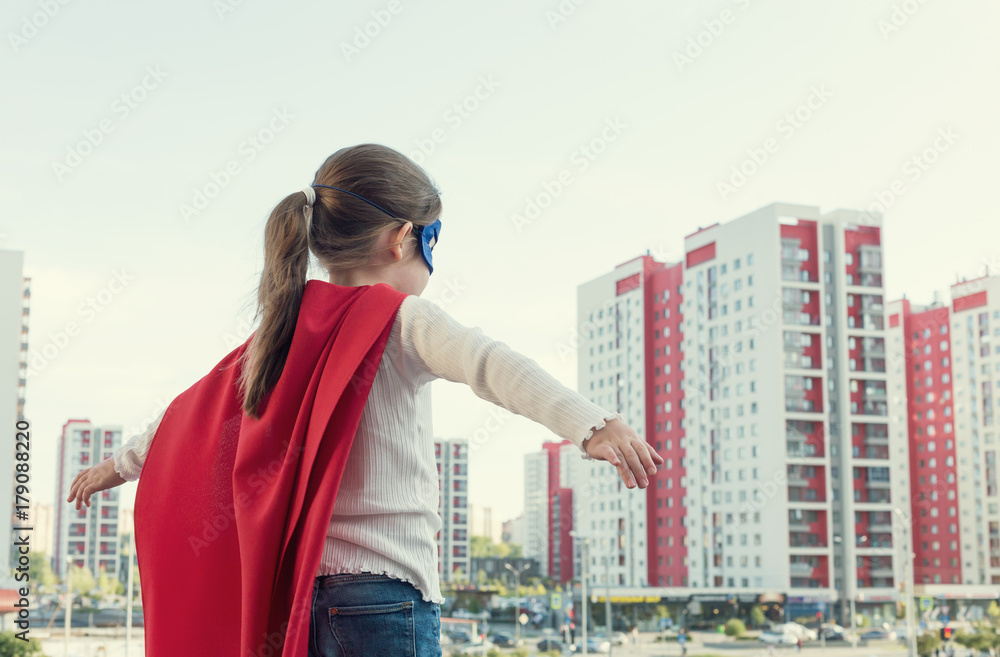 Superhero kid against blue sky background. Girl power concept Superhero kid against blue sky background. Girl power concept