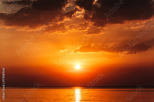 Beautiful and dramatic red and orange marine sunset with clouds. Nobody, clear sea, perfect nature background.