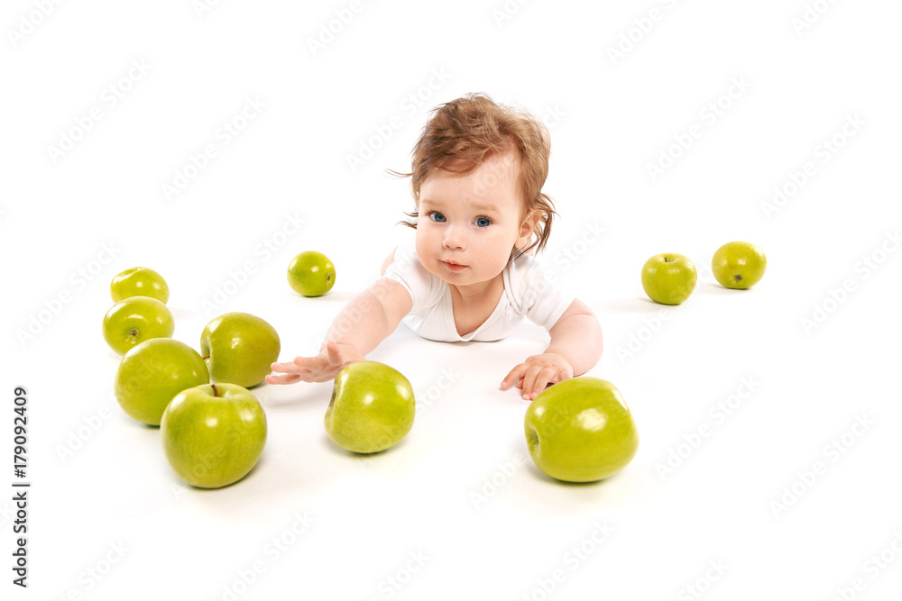 little boy on the floor with green apples little boy on the floor with green apples