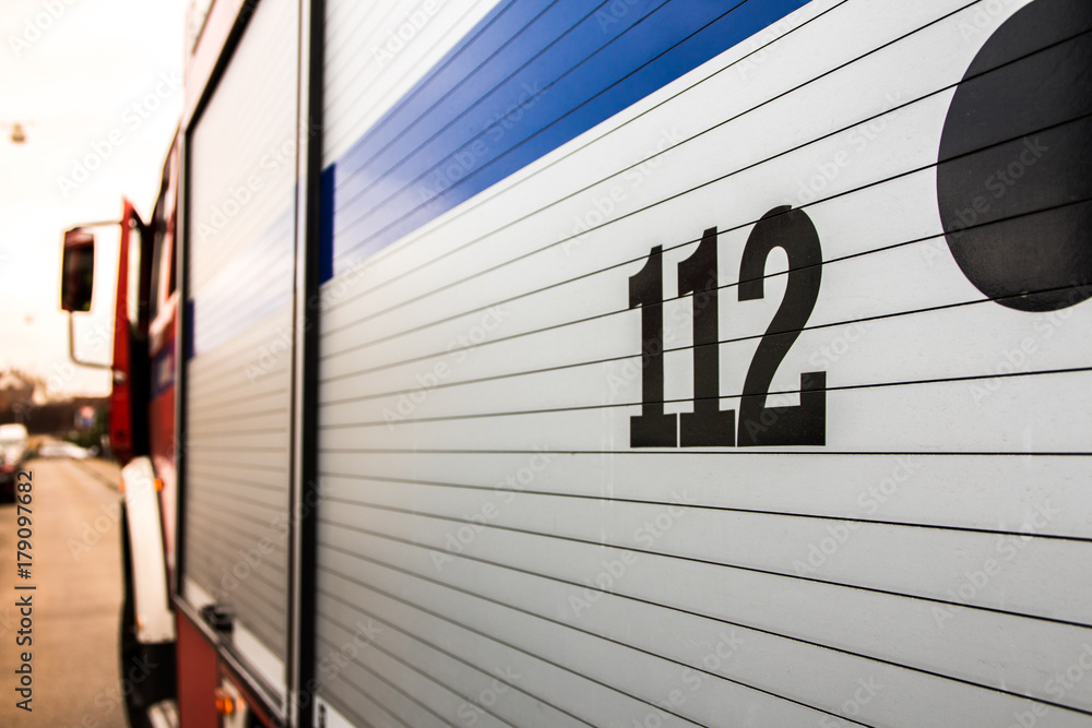 Feuerwehrauto mit Notrufnummer 112 im Sonnenlicht Feuerwehrauto mit Notrufnummer 112 im Sonnenlicht