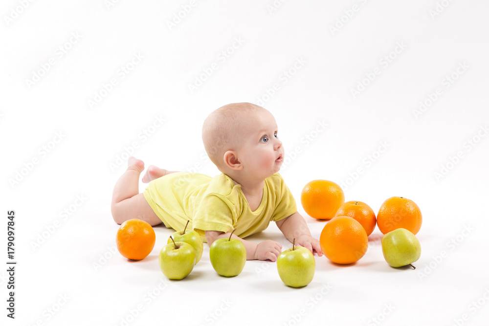 cute smiling healthy child lies on a white background among fruit cute smiling healthy child lies on a white background among fruit