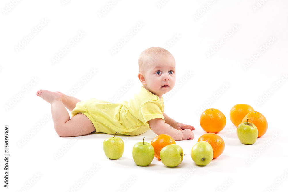 cute smiling healthy child lies on a white background among fruit cute smiling healthy child lies on a white background among fruit