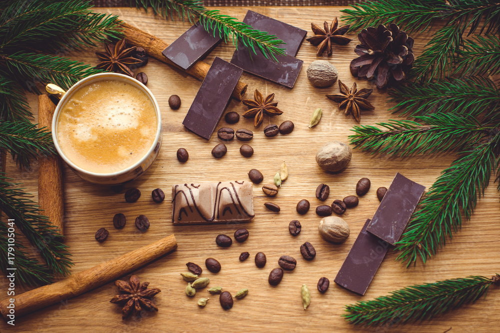 Hot coffee and christmas decorations . Cup of coffee and chocolate on wooden table. Christmas decorations on a kitchen, gifts and food on a wooden background. Magic moments in everyday life Hot coffee and christmas decorations . Cup of coffee and chocolate on wooden table. Christmas decorations on a kitchen, gifts and food on a wooden background. Magic moments in everyday life