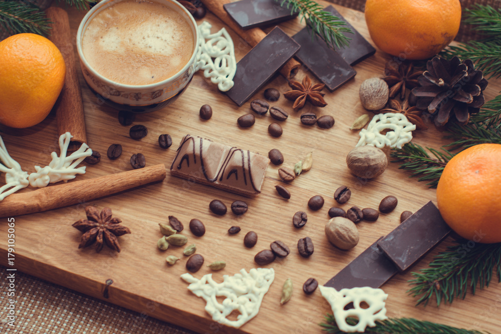 Hot coffee and christmas decorations . Cup of coffee and chocolate on wooden table. Christmas decorations on a kitchen, gifts and food on a wooden background. Magic moments in everyday life Hot coffee and christmas decorations . Cup of coffee and chocolate on wooden table. Christmas decorations on a kitchen, gifts and food on a wooden background. Magic moments in everyday life