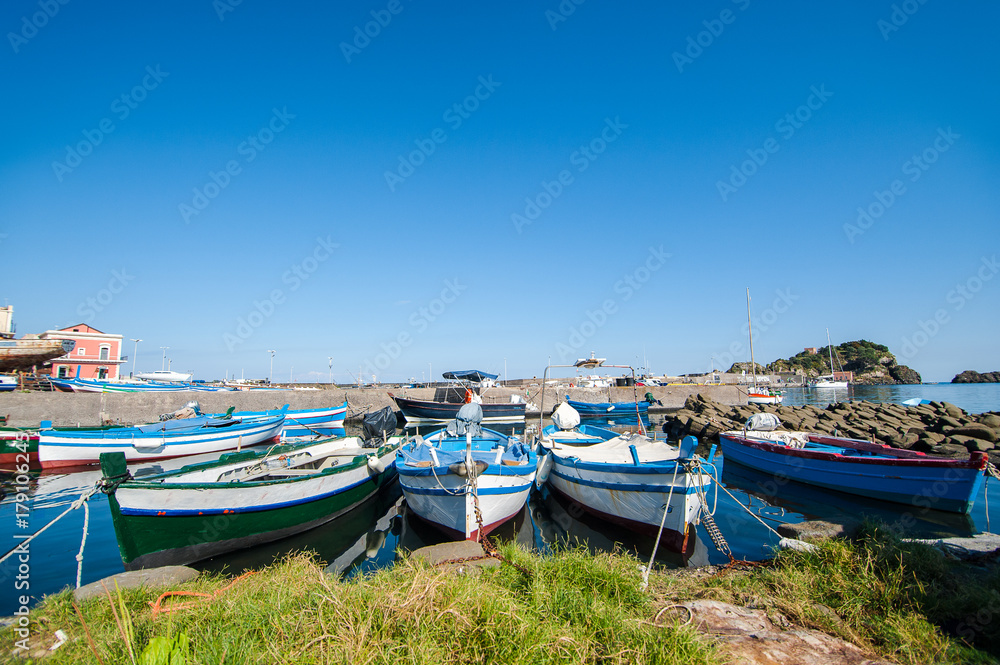 Sicilian landscape: fisher boats  with the Islands of the Cyclops on the background