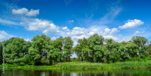 Summer river with bright blue sky and clouds