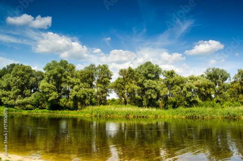 Fototapeta Naklejka Na Ścianę i Meble -  Summer river with bright blue sky and clouds