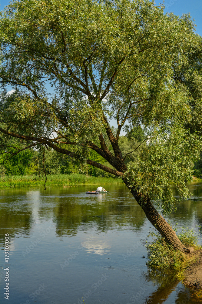 Tourists float on a raft down the river - a summer holiday. Tourists on the Seversky Donets River, Ukraine - summer landscape. Tourists float on a raft down the river - a summer holiday. Tourists on the Seversky Donets River, Ukraine - summer landscape.