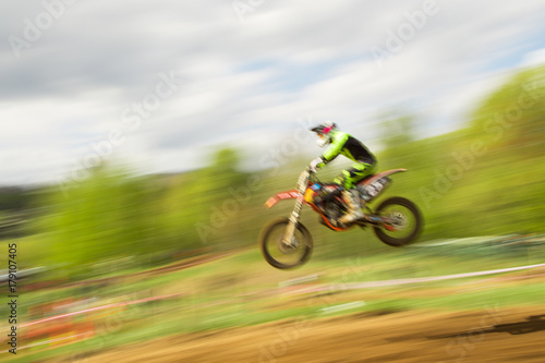 Biker on motocross jump in motion