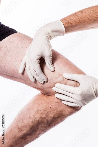 Doctor in medical gloves examines a person with varicose veins of the lower extremities and venous thrombophlebitis and on a white background