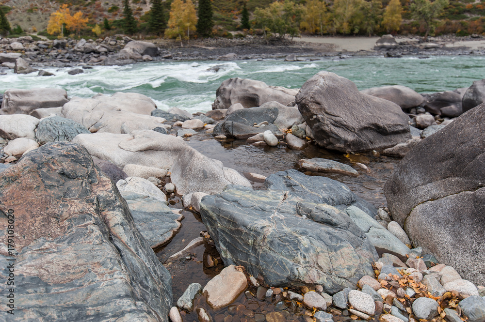 huge rocks on the shore of the turquoise river huge rocks on the shore of the turquoise river